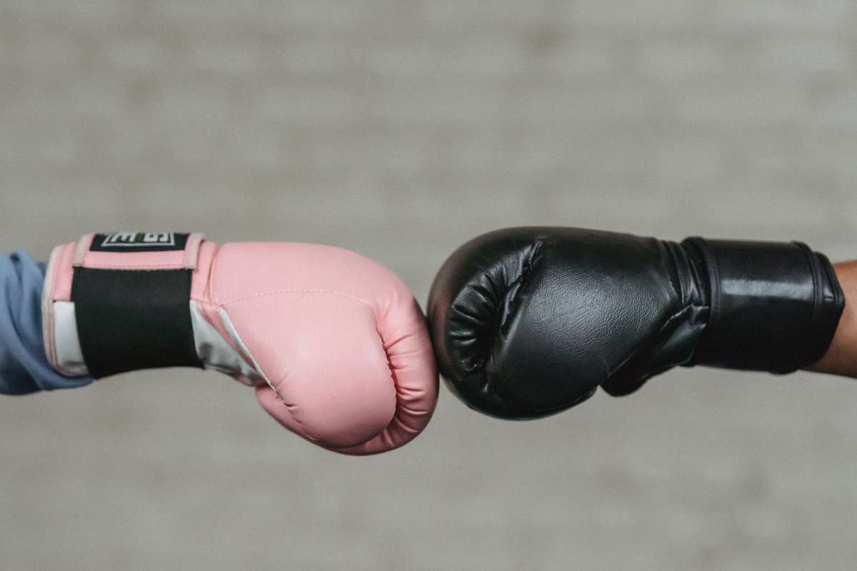 Determined, tough young female boxer shadowboxing in gym